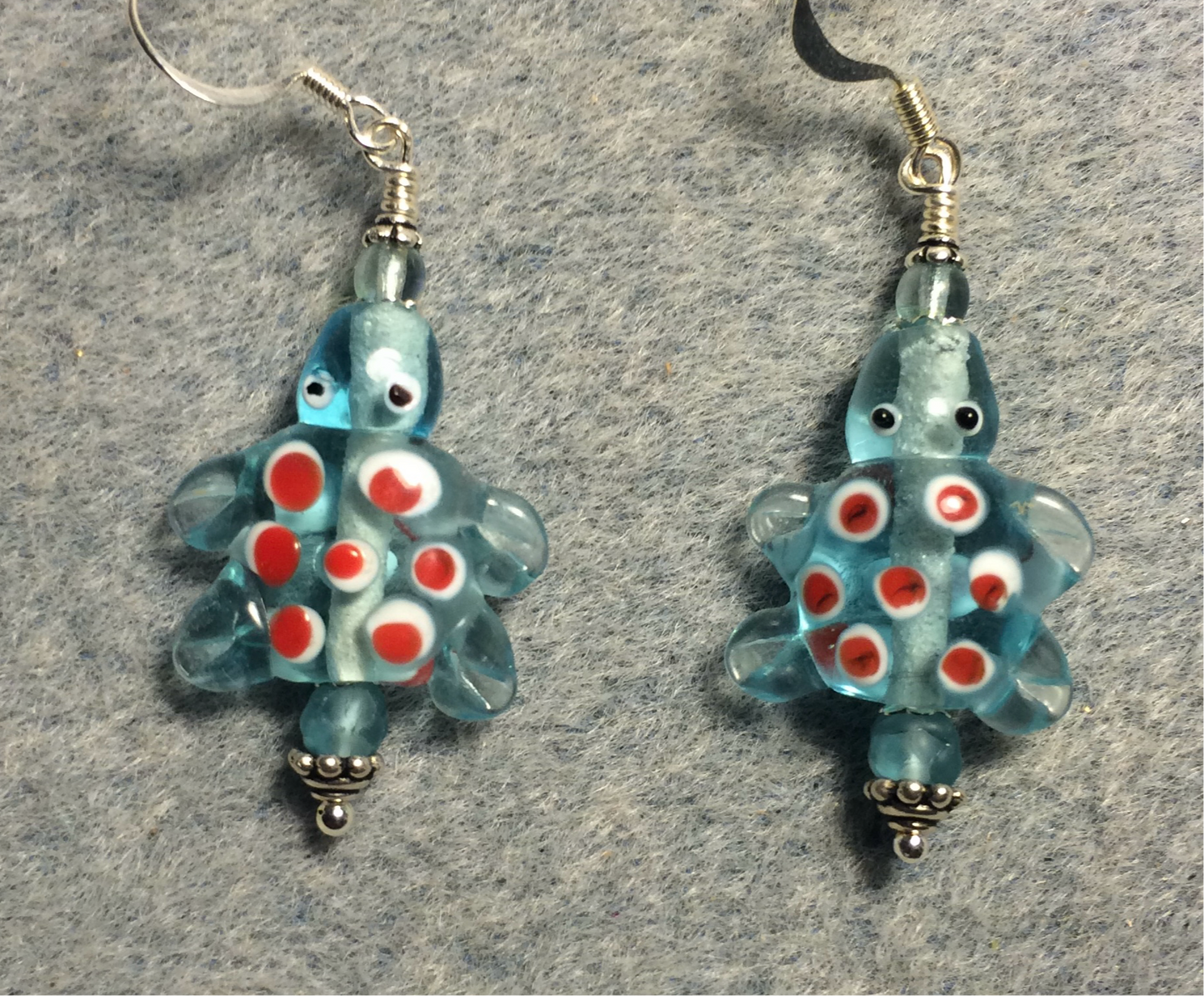 Light turquoise with red spots lamp work turtle bead earrings adorned with light turquoise Czech glass beads.