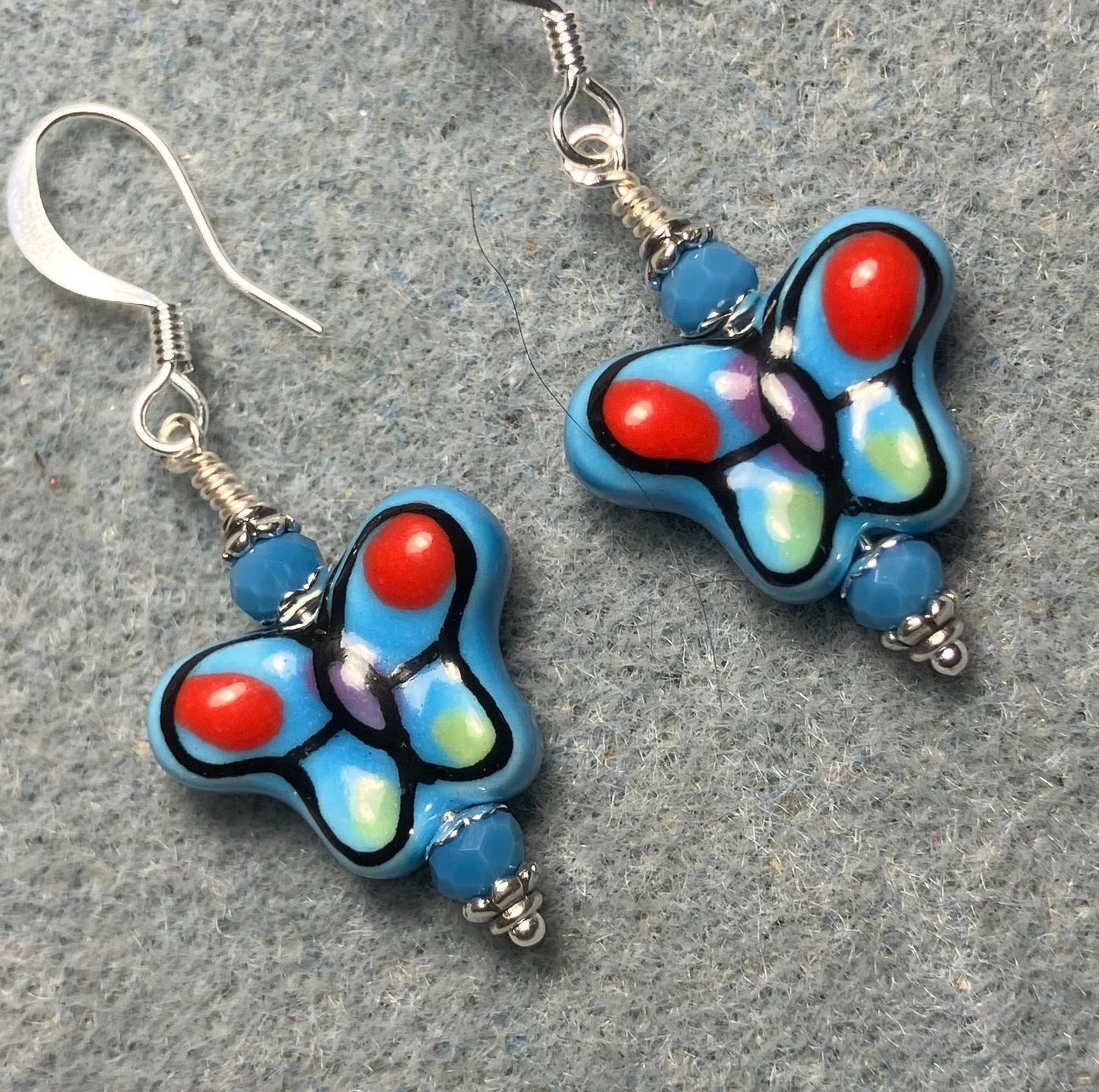 Blue and red ceramic butterfly bead earrings adorned with blue Chinese crystal beads.