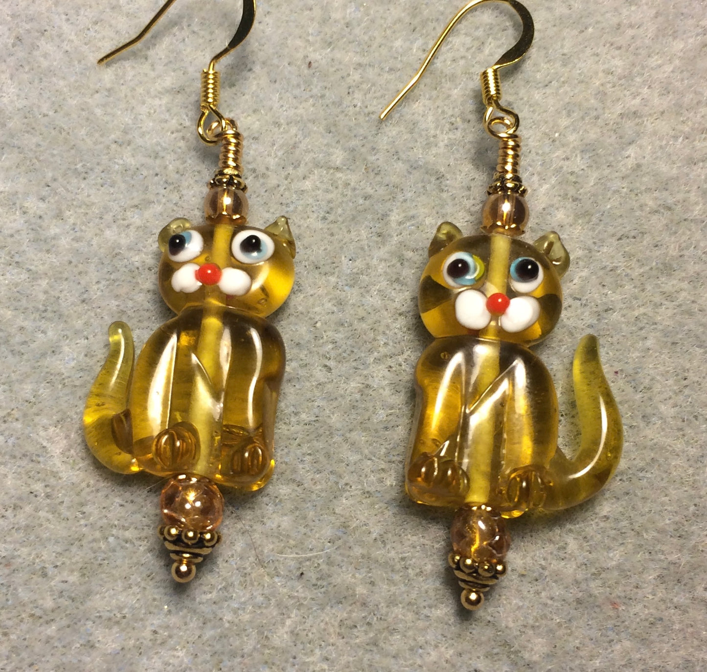 Translucent light amber lamp work cat bead earrings adorned with amber Czech glass beads.