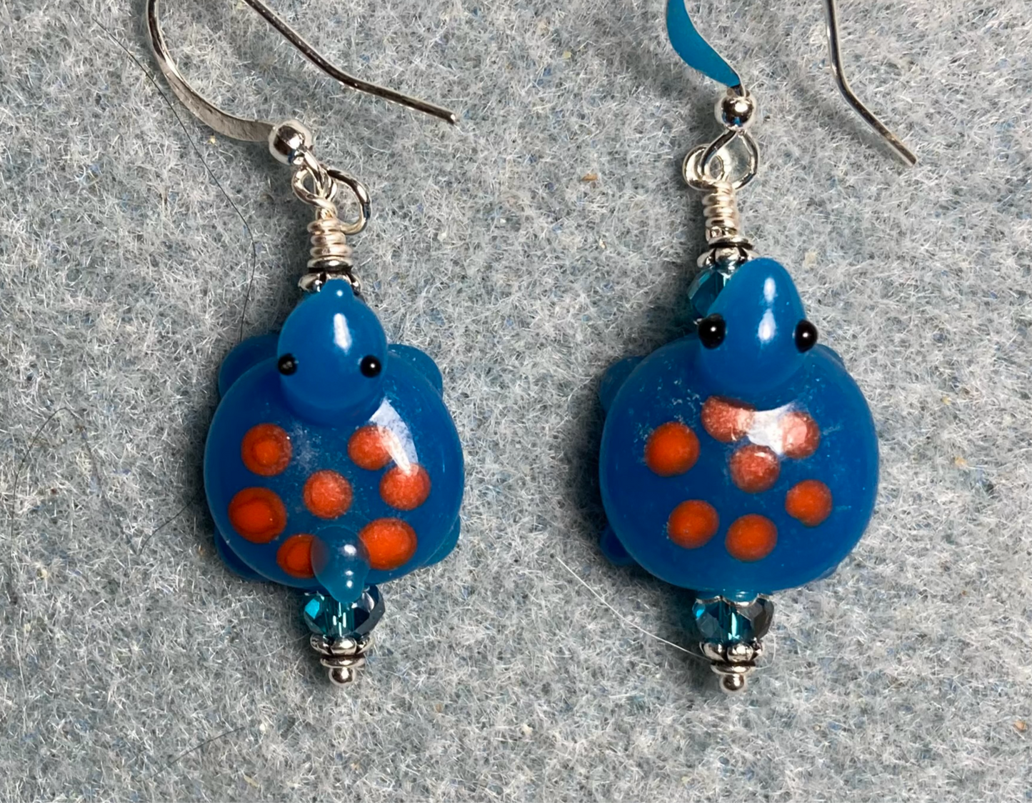 Turquoise with orange spots lamp work turtle bead earrings adorned with turquoise Chinese crystal beads.