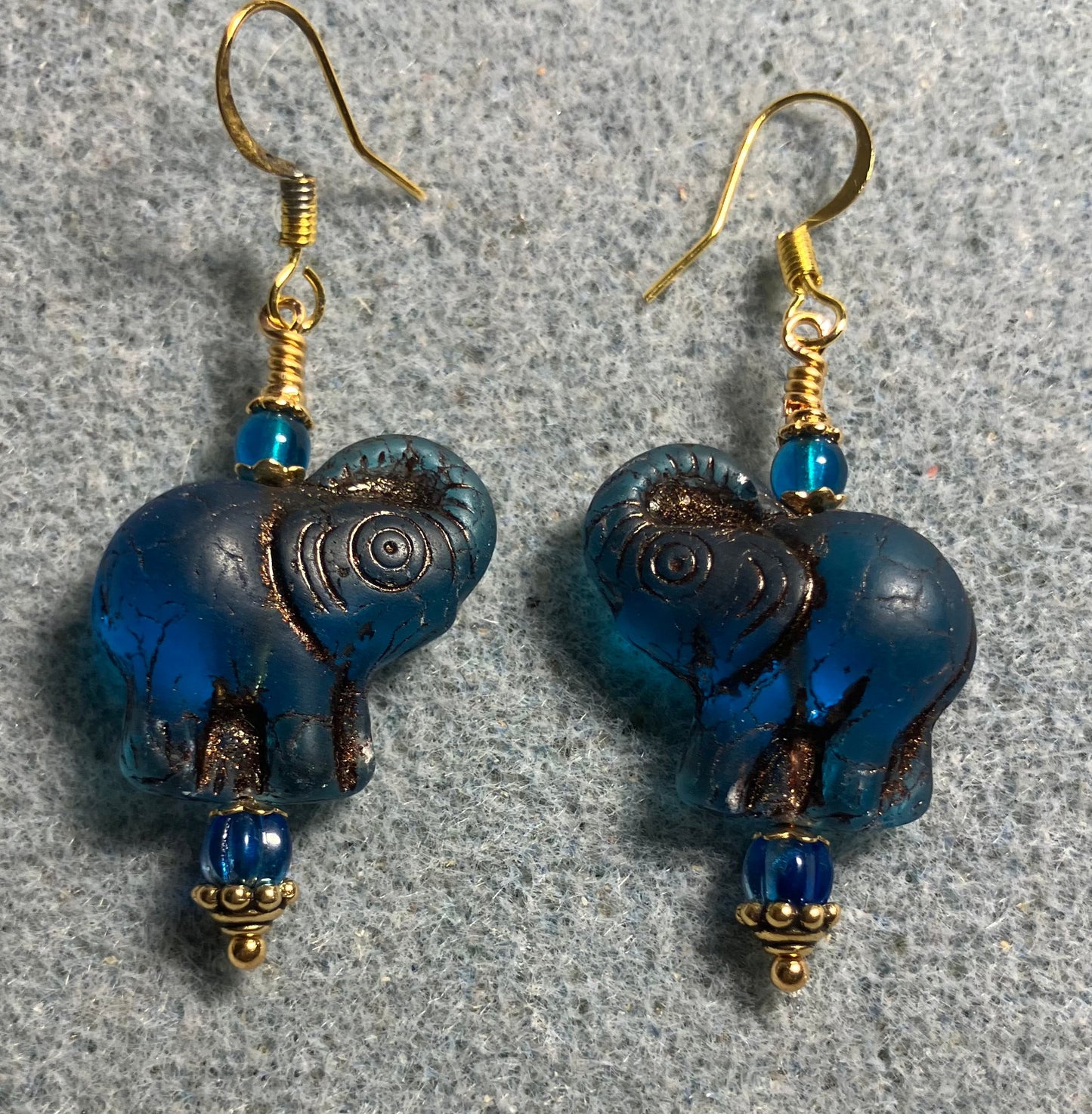 Dark turquoise (with copper inlay) Czech glass elephant bead earrings adorned with turquoise Czech glass beads.