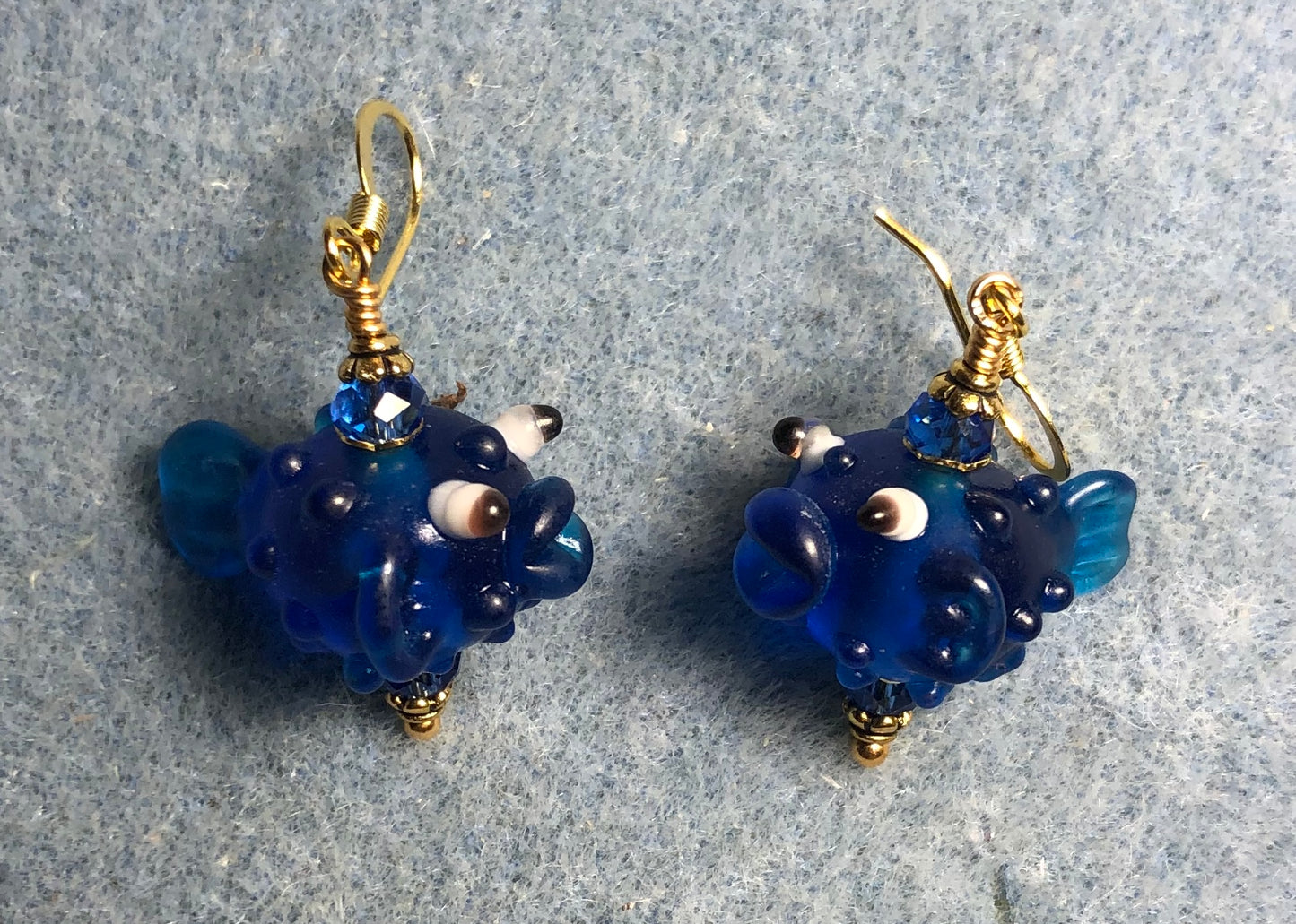 Translucent bright blue lamp work fish bead earrings adorned with bright blue Chinese crystal beads.