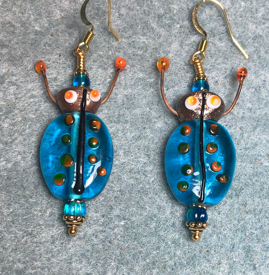 Translucent turquoise and orange lamp work beetle bead earrings adorned with turquoise  Czech glass beads.