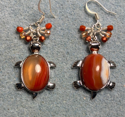 Large silver and red agate gemstone turtle charm earrings adorned with small dangling orange Czech glass beads.