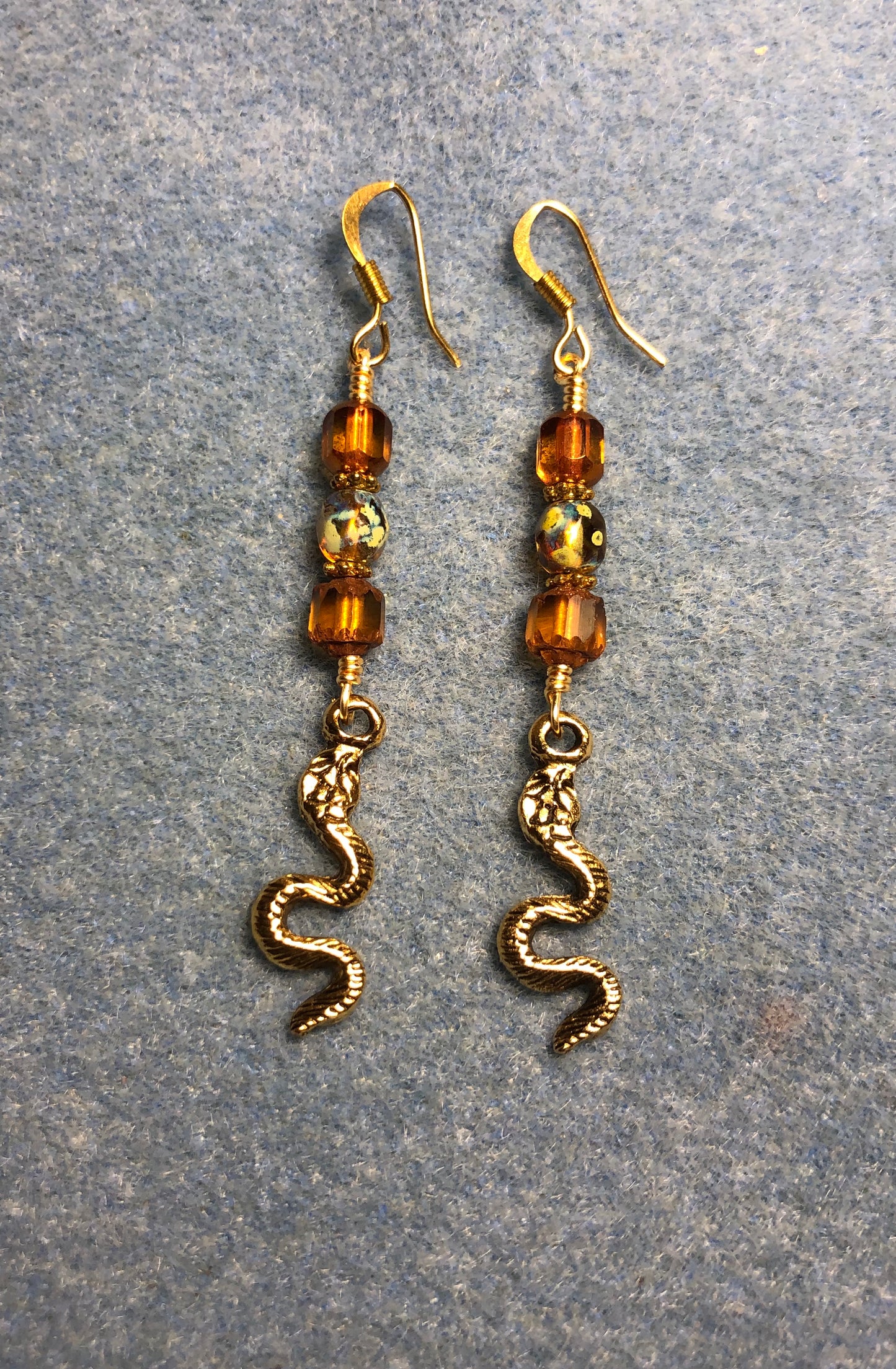 Gold snake charm earrings adorned with amber Czech glass beads
