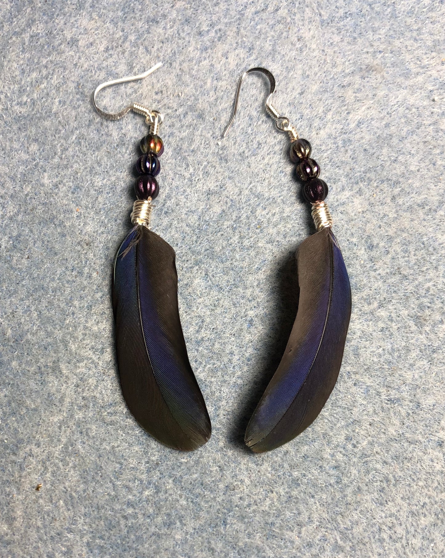 Purple Pionus parrot feather earrings adorned with small purple Czech glass beads.