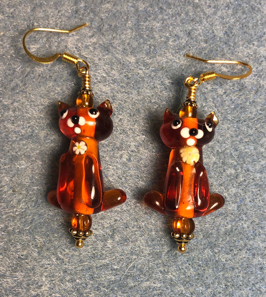 Translucent amber lamp work cat bead earrings adorned with amber Czech glass beads.