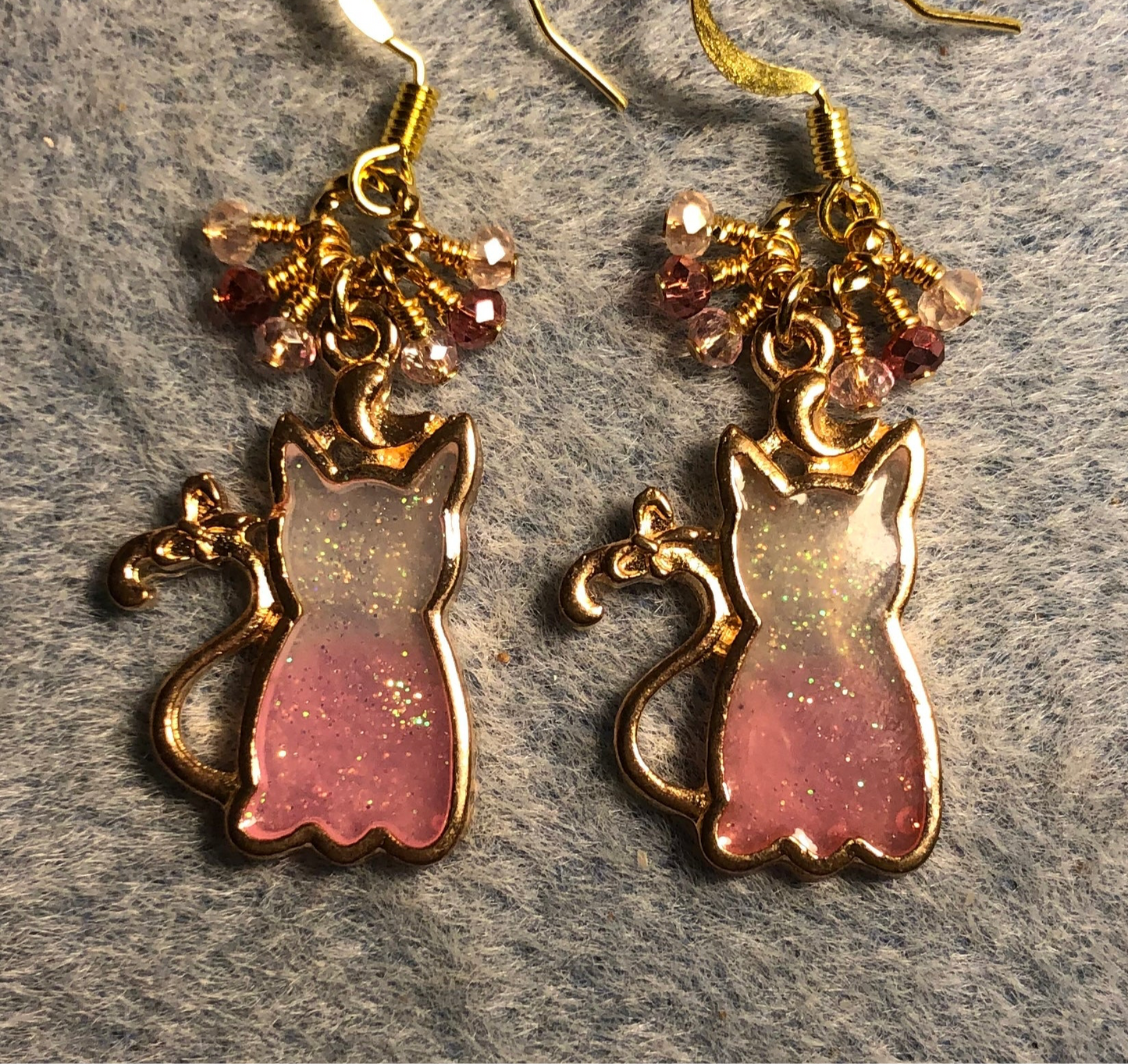 Pink and gold sparkly resin cat charm earrings adorned with small dangling pink and gold Chinese crystal beads.