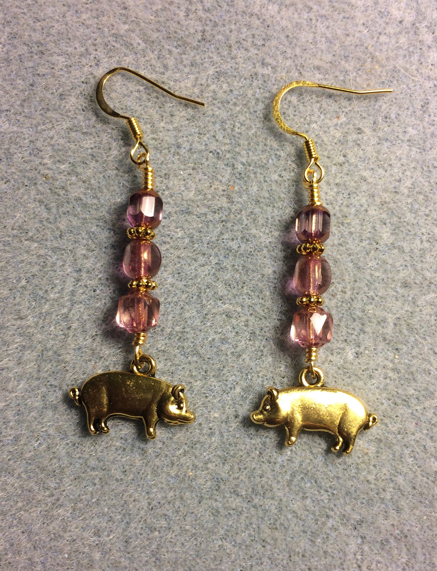 Gold pig charm earrings adorned with pink Czech glass beads