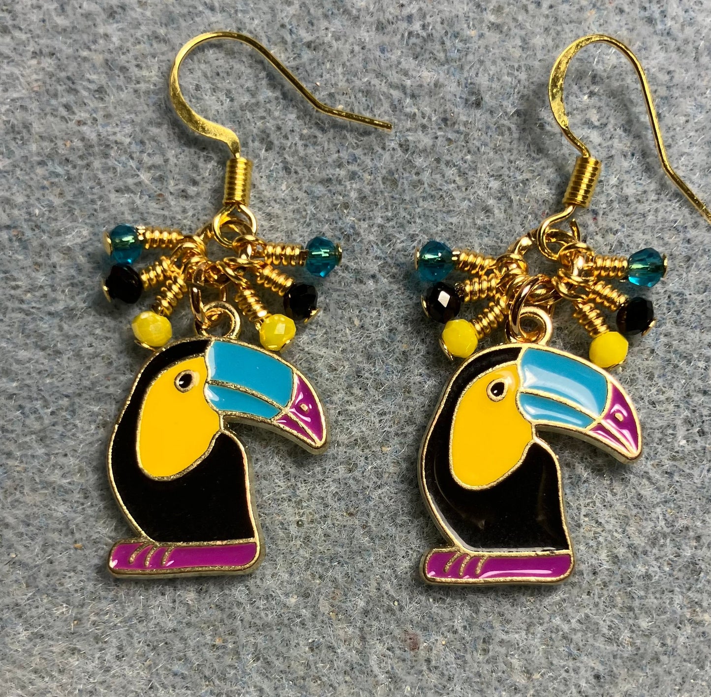 Black, yellow, turquoise, and rose enamel toucan charm earrings adorned with tiny dangling black, yellow, and turquoise Chinese crystal beads.