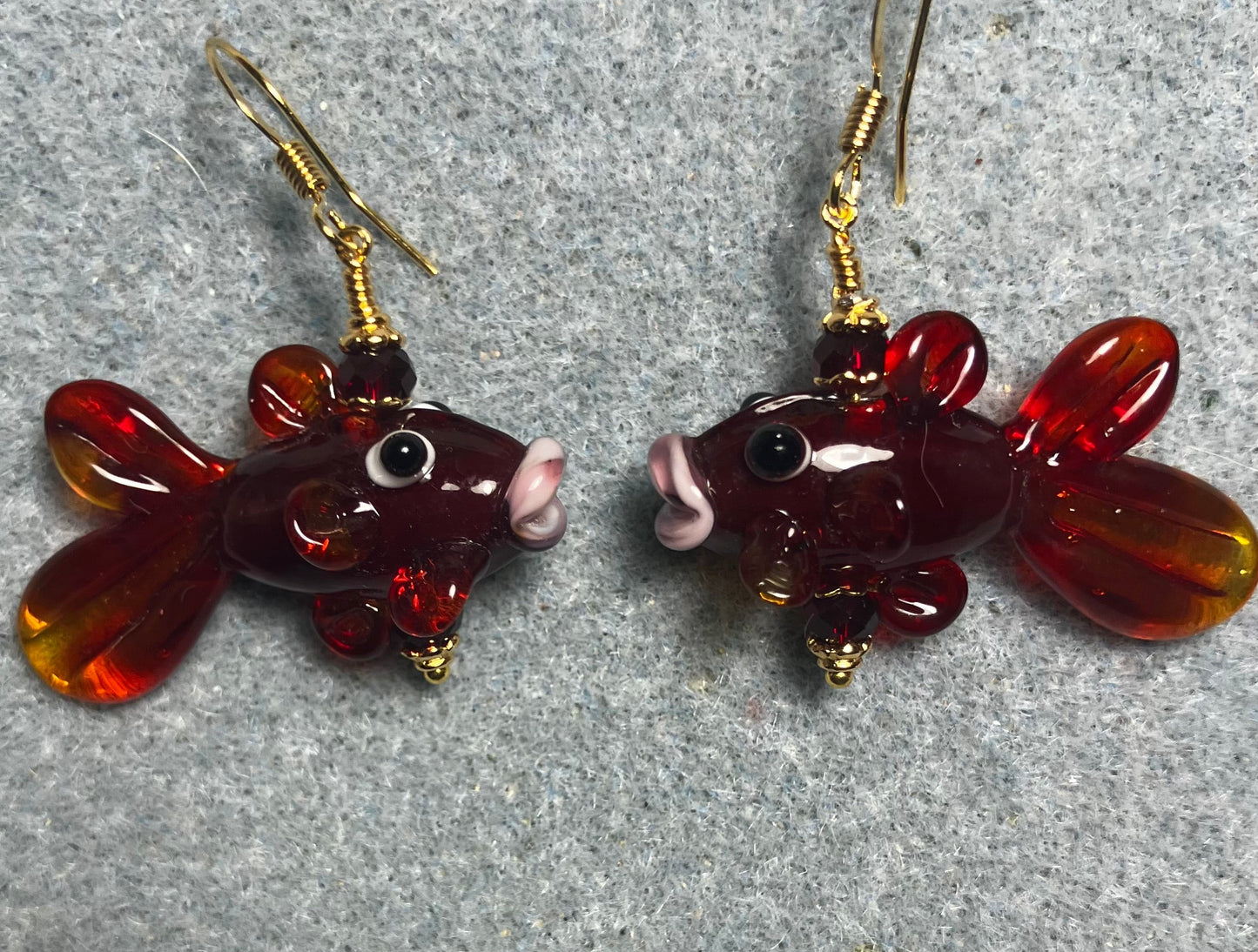 Translucent dark red lamp work fish bead earrings adorned with dark red Chinese crystal beads.