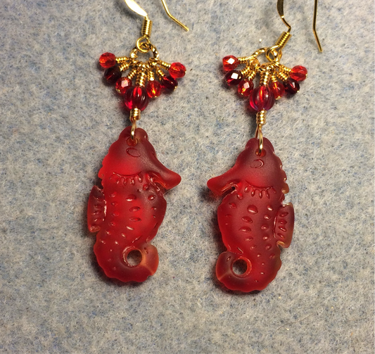 Bright red sea glass seahorse pendant bead earrings adorned with red Czech glass beads and small dangling red Czech glass beads.
