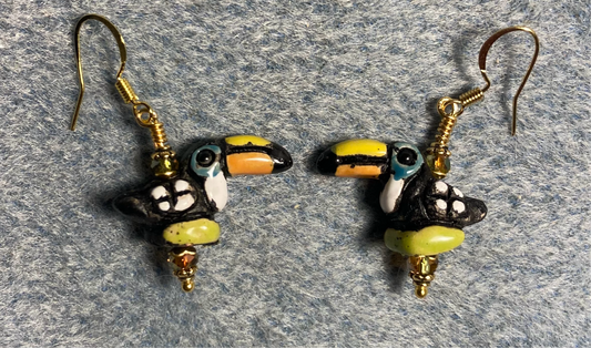 Small black, orange, green, and white ceramic toucan bead earrings adorned with small sparkly green Chinese crystal beads.