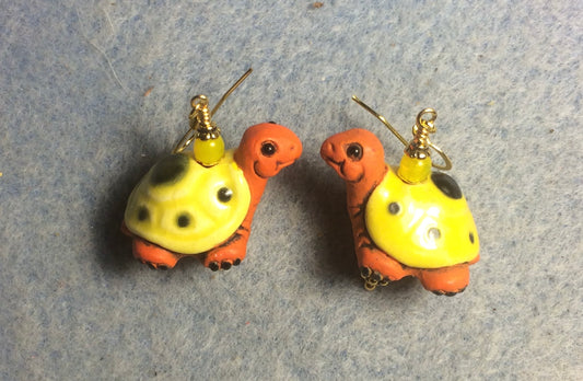 Large orange and yellow ceramic turtle bead earrings adorned with yellow Czech glass beads.