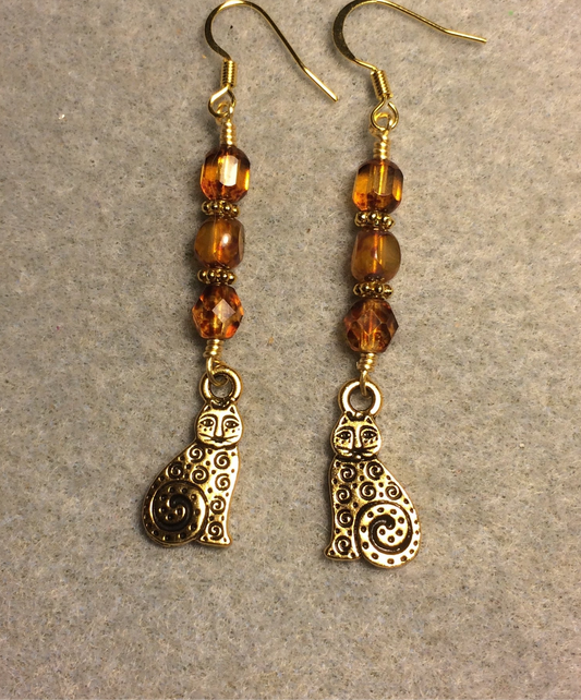 Gold swirly cat charm earrings adorned with amber Czech glass beads