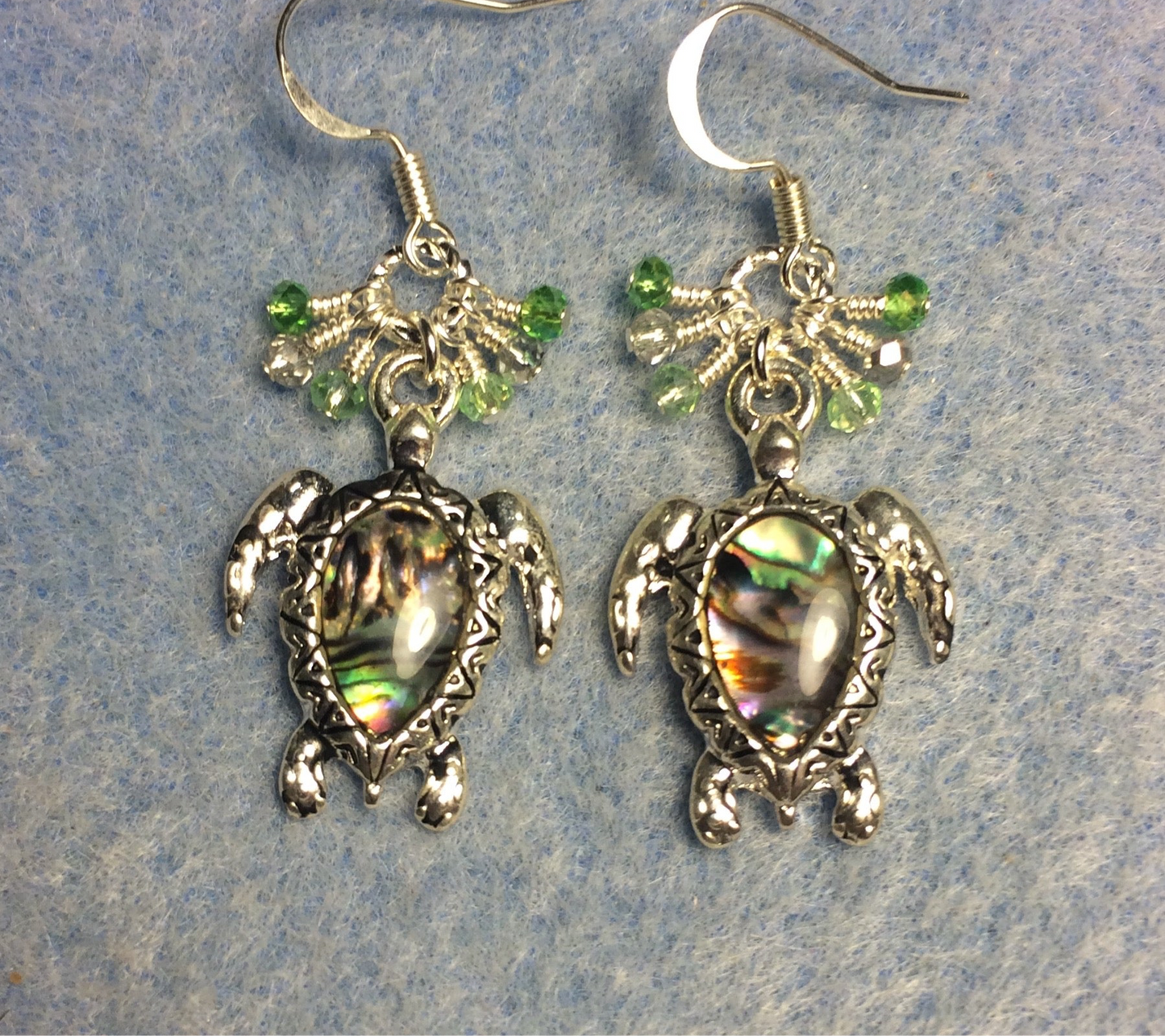 Silver and abalone turtle charm earrings adorned with small dangling light green and silver Chinese crystal beads.