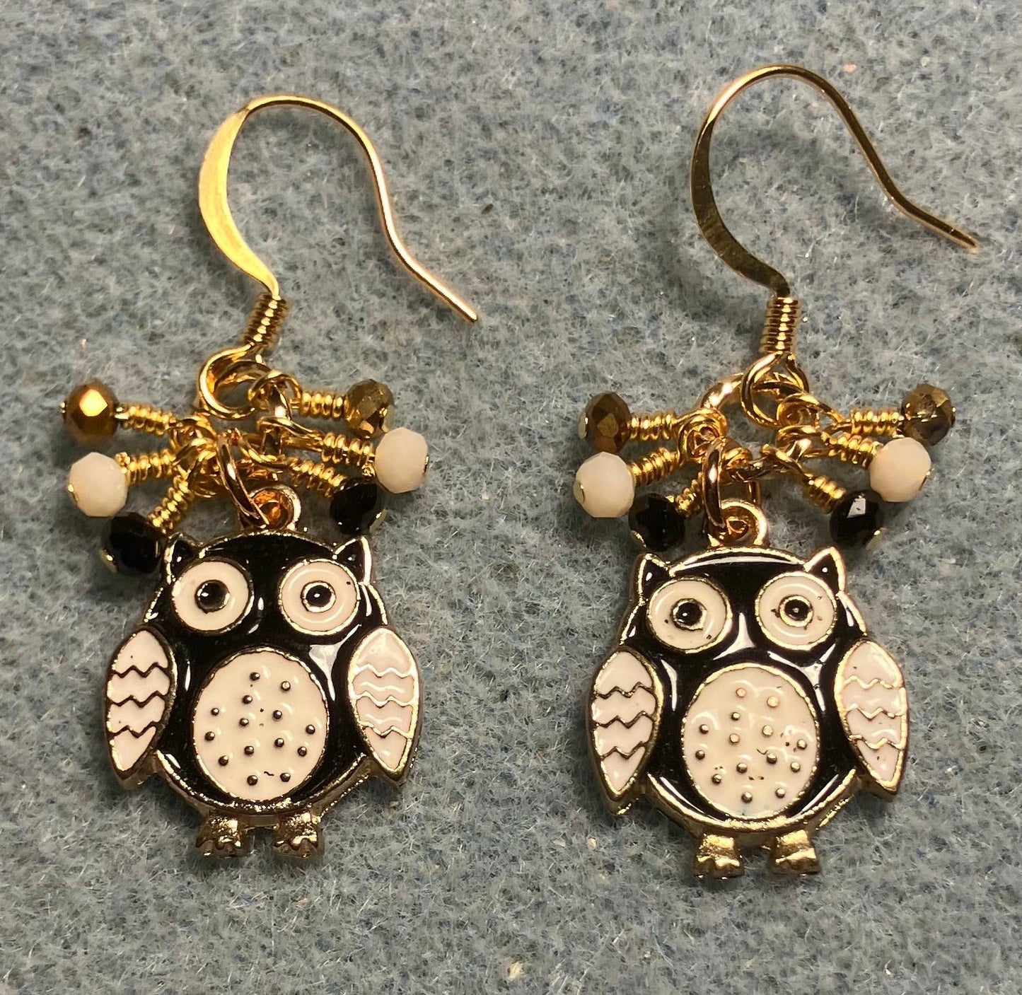 Black, white, and gold enamel owl charm earrings adorned with tiny dangling black, white, and gold Chinese crystal beads.
