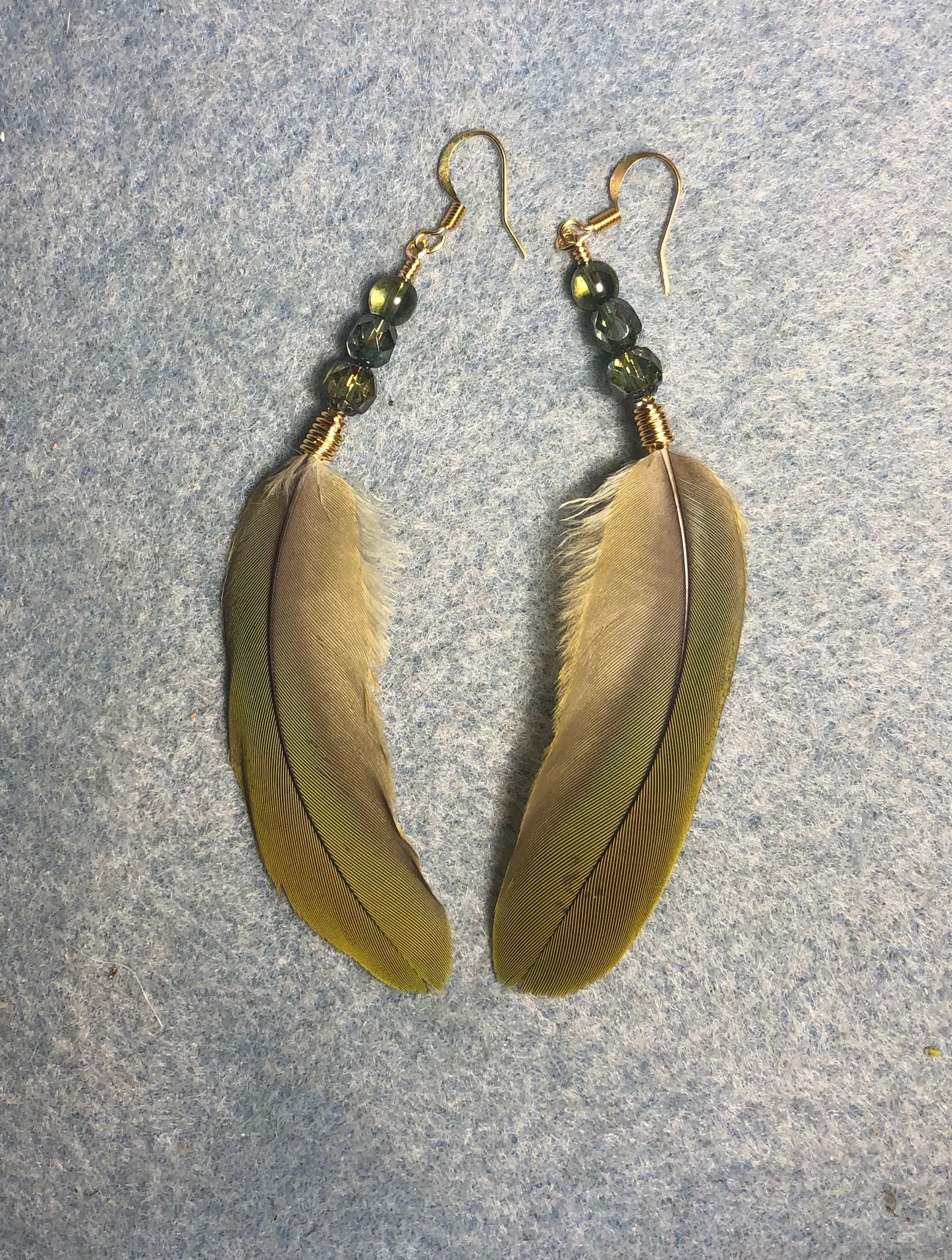 Olive green red-fronted macaw feather earrings adorned with olive green Czech glass beads.