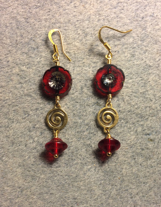 Translucent red Czech glass pansy bead earrings adorned with gold swirly connectors and translucent red Czech glass Saturn beads.