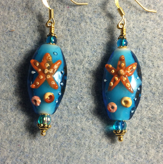Turquoise and orange lamp work starfish bead earrings adorned with turquoise Czech glass beads.