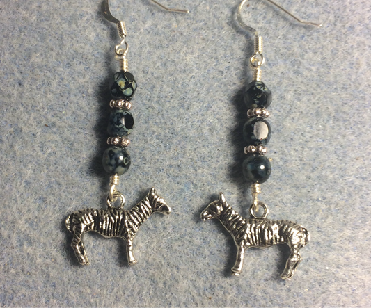 Silver zebra charm earrings adorned with black Picasso Czech glass beads.