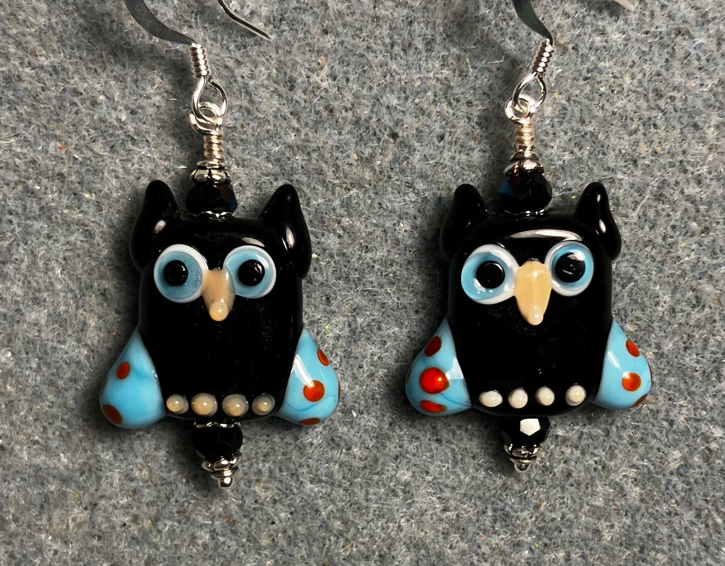 Black and blue lamp work owl bead earrings adorned with black Chinese crystal beads.