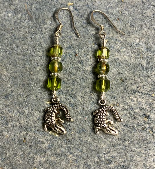 Silver alligator charm earrings adorned with olive green Czech glass beads.