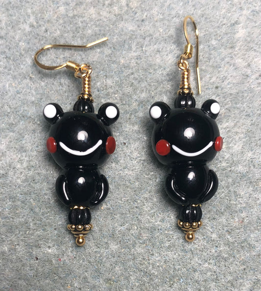 Opaque black lamp work frog bead earrings adorned with black Czech glass beads.