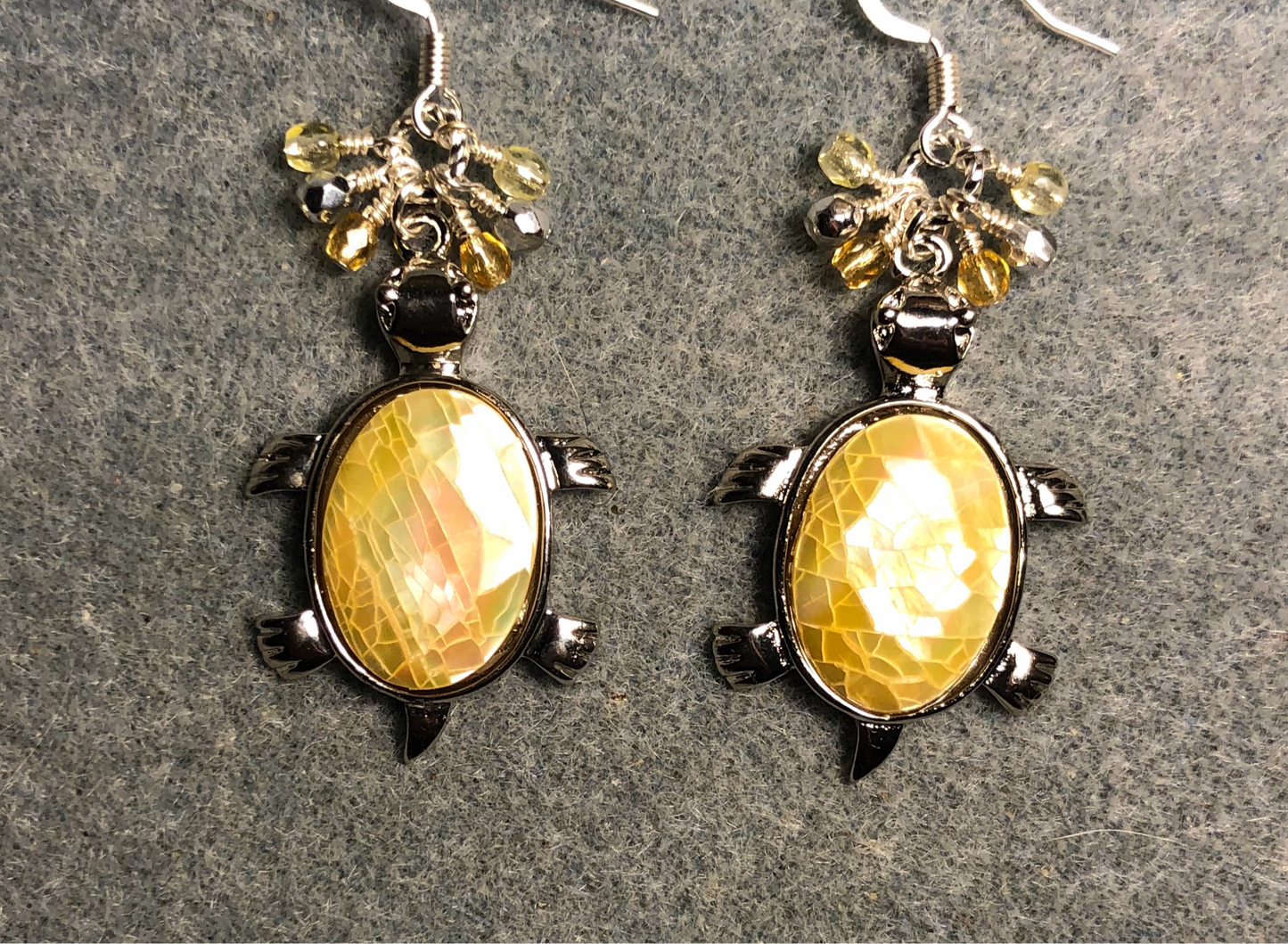 Large silver and yellow shell turtle charm earrings adorned with small dangling amber, yellow, and silver Czech glass beads.