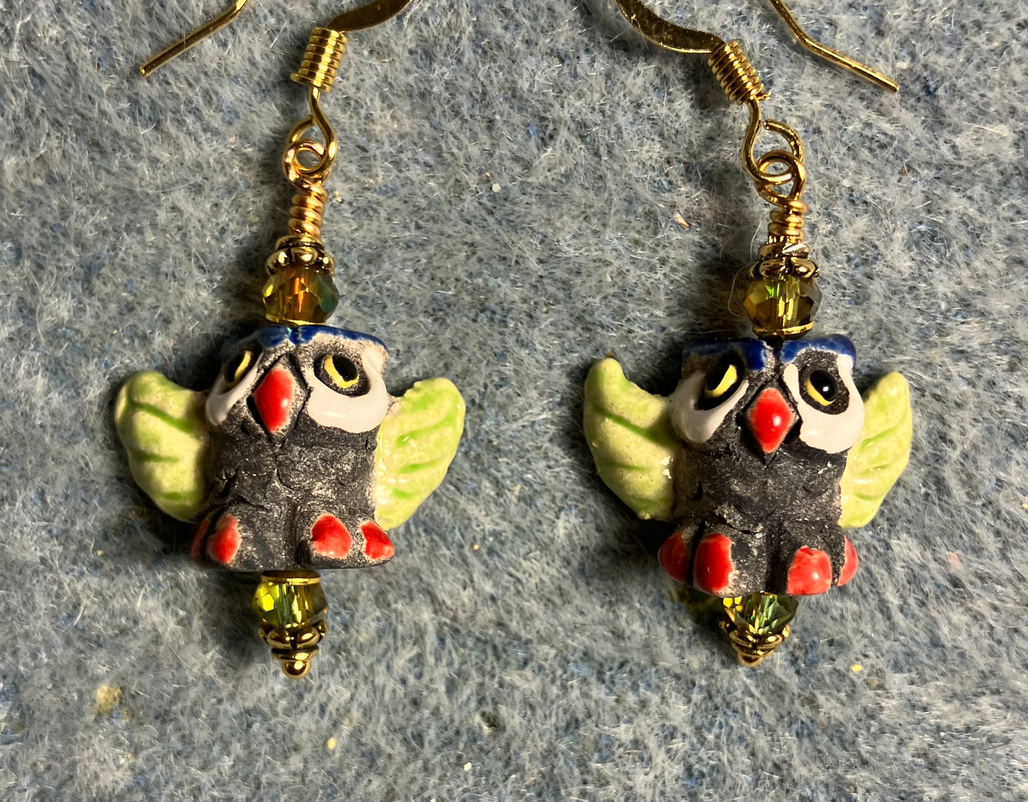 Small dark gray, red, and olive green ceramic flying owl bead earrings adorned with sparkly olive green Chinese crystal beads.