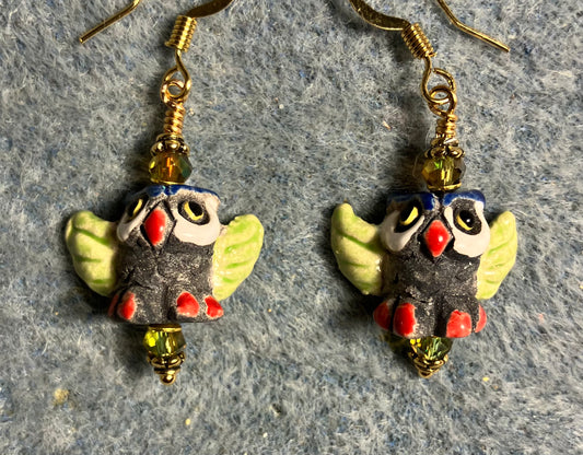 Small dark gray, red, and olive green ceramic flying owl bead earrings adorned with sparkly olive green Chinese crystal beads.