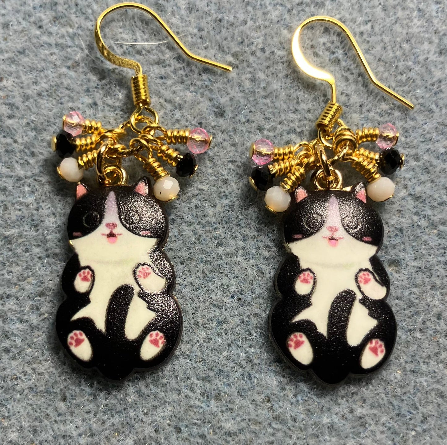Black, white, and pink enamel cat charm earrings adorned with tiny dangling black, white, and pink Chinese crystal beads.