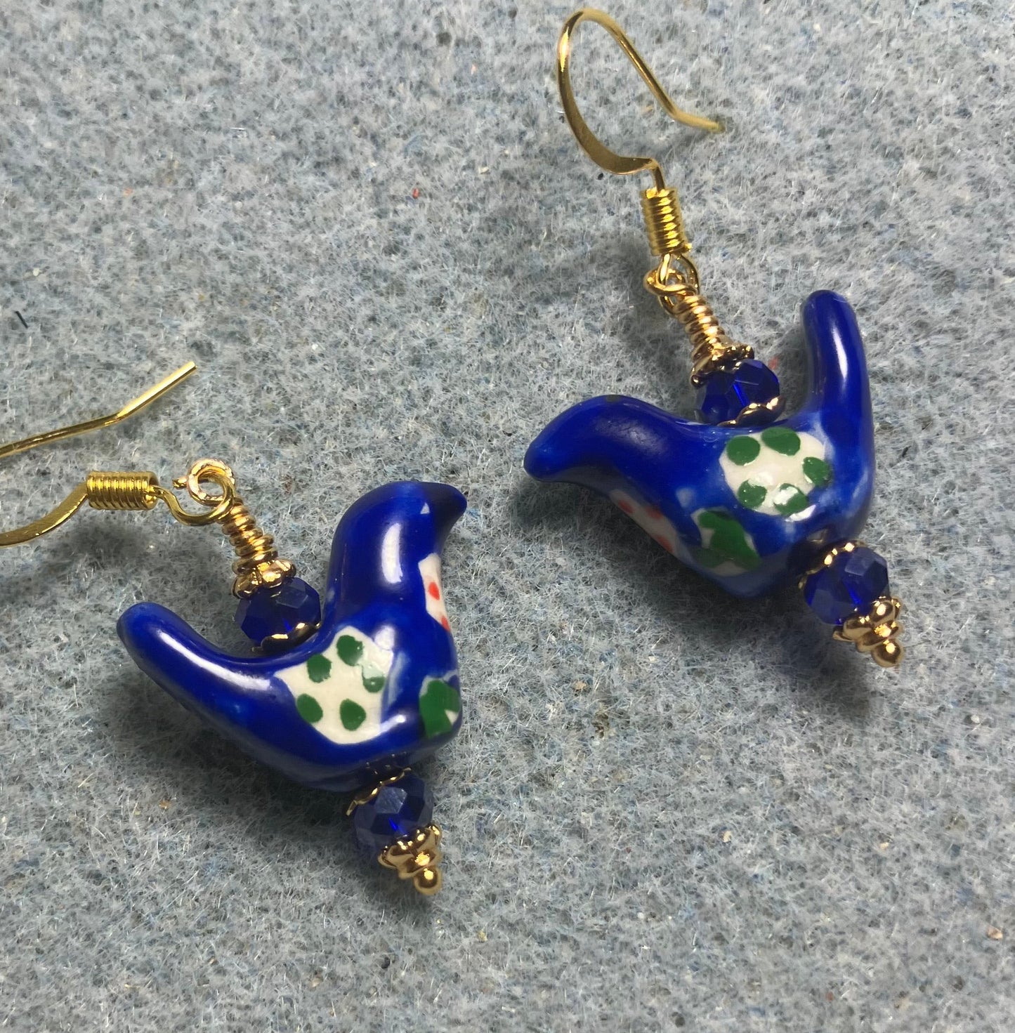 Small dark blue, white, and green ceramic bird bead earrings adorned with dark blue Chinese crystal beads.