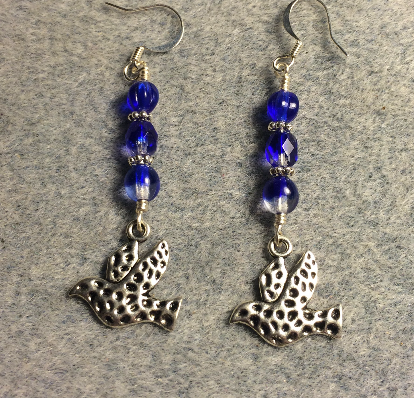 Silver spotted dove charm earrings adorned with dark blue Czech glass beads