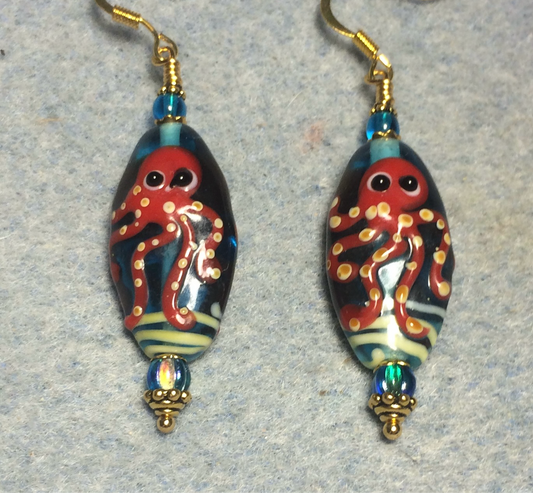 Turquoise and dark red lamp work octopus bead earrings adorned with turquoise Czech glass beads.