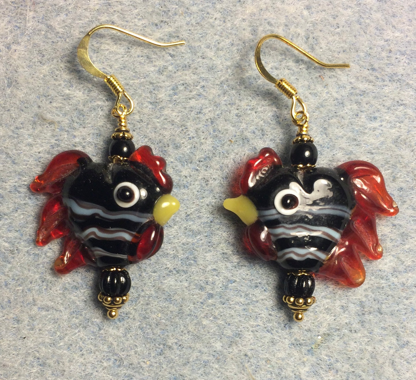 Black with white stripes heart shaped lamp work rooster bead earrings adorned with black Czech glass beads.