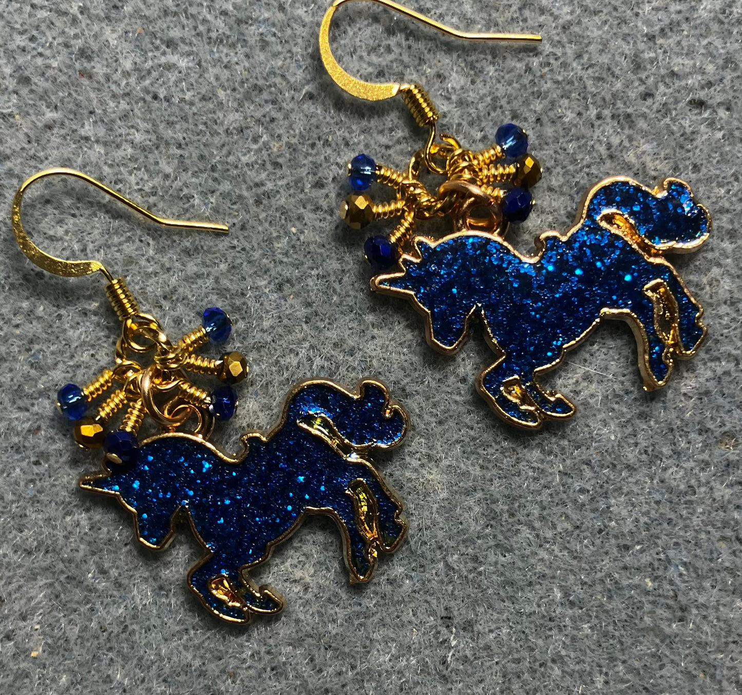 Dark blue and gold enamel sparkly unicorn charm earrings adorned with tiny dangling dark blue and gold Chinese crystal beads.