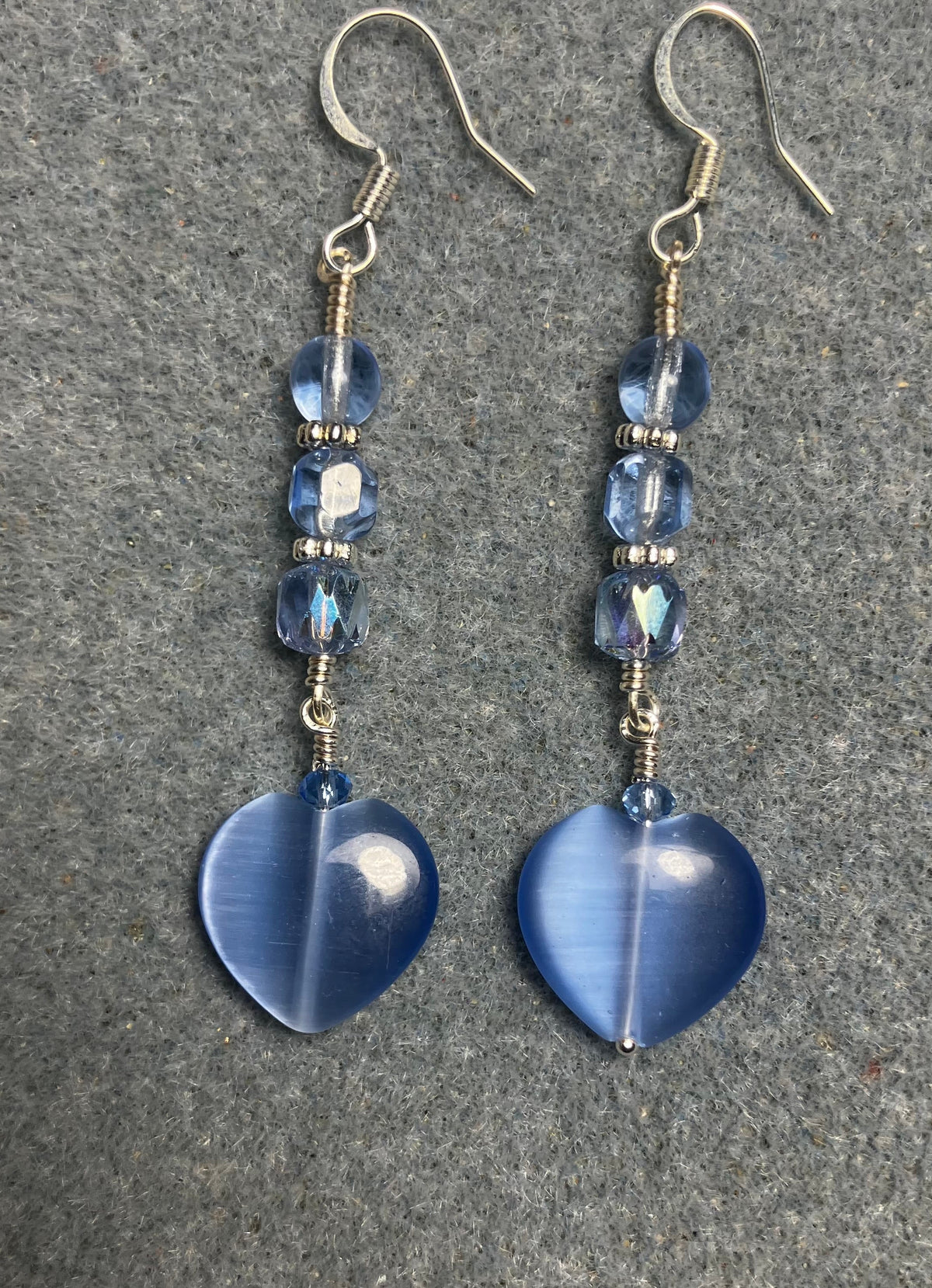 Light blue fiber optic (cat’s eye) Czech glass heart bead earrings adorned with light blue Czech glass beads.