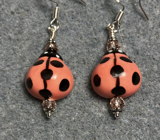 Coral pink and black ceramic ladybug bead earrings adorned with coral pink Chinese crystal beads.