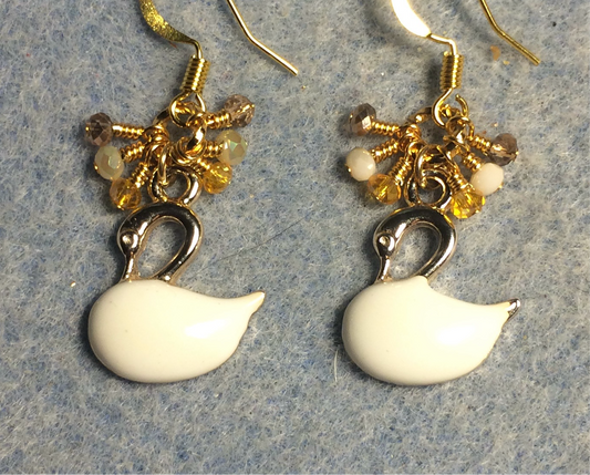 Gold and off white enamel swan charm earrings adorned with tiny dangling off white, gold, and amber Chinese crystal beads.