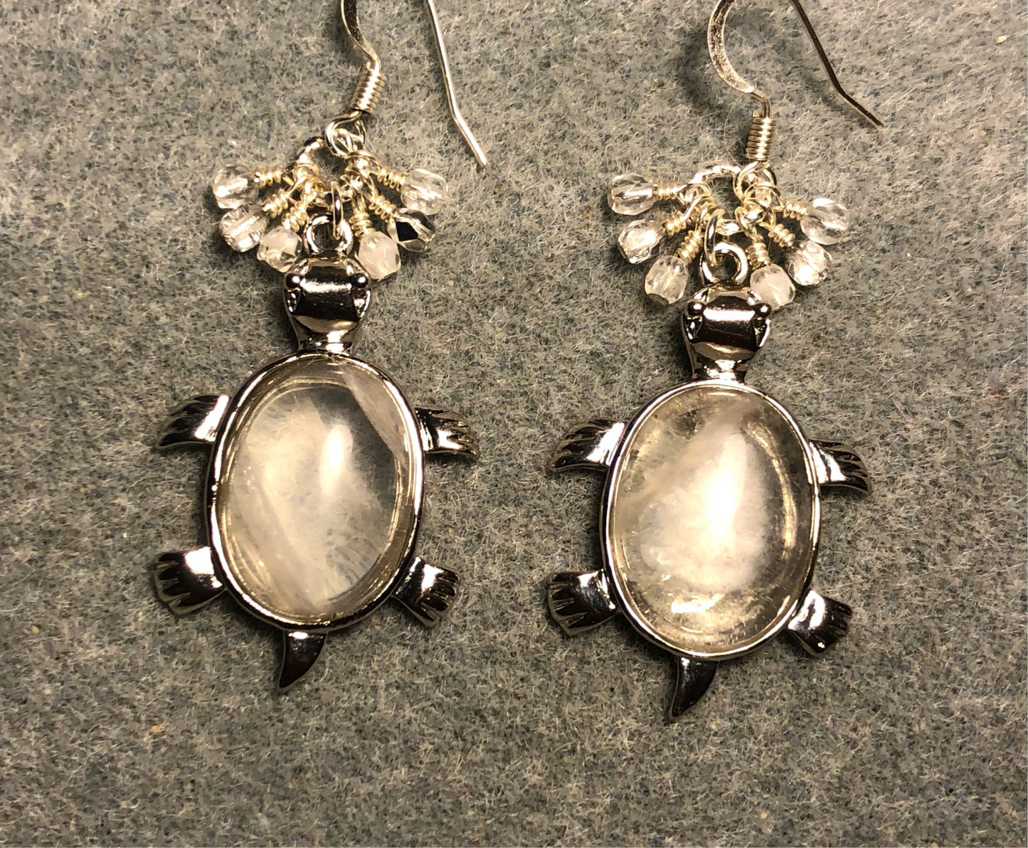 Large silver and rock crystal gemstone turtle charm earrings adorned with small dangling clear and silver Czech glass beads.