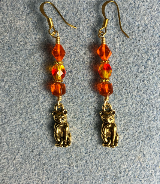 Gold cat charm earrings adorned with orange Czech glass beads