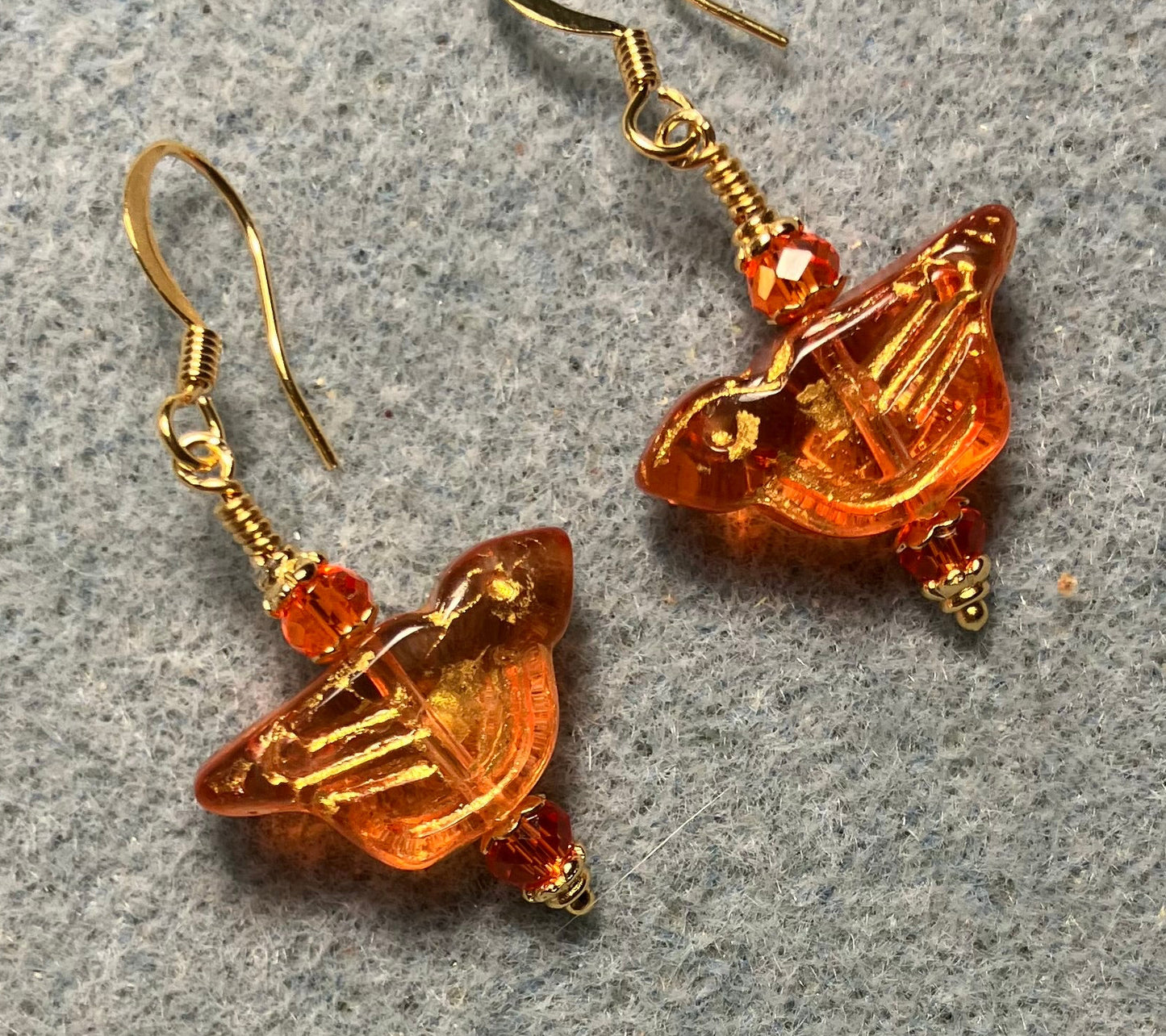 Translucent orange (with gold wash) Czech glass bird bead earrings adorned with orange Chinese crystal beads.