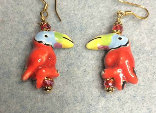 Red ceramic toucan bead earrings adorned with red Chinese crystal beads.