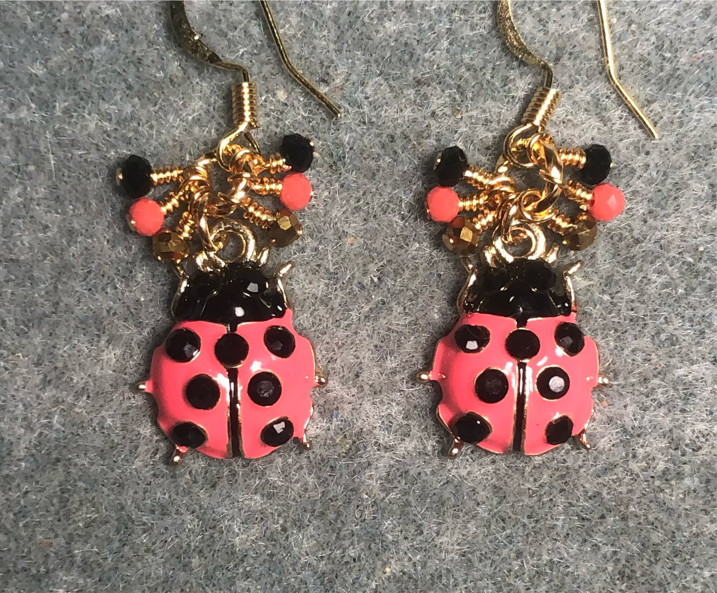 Hot pink and black enamel ladybug charm earrings adorned with tiny dangling hot pink, black, and gold Chinese crystal beads.