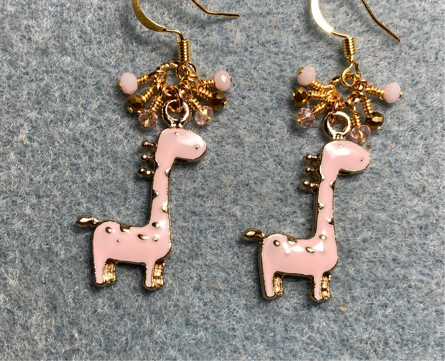 Light pink enamel spotted giraffe charm earrings adorned with tiny dangling pink, gold, and peach Chinese crystal beads.