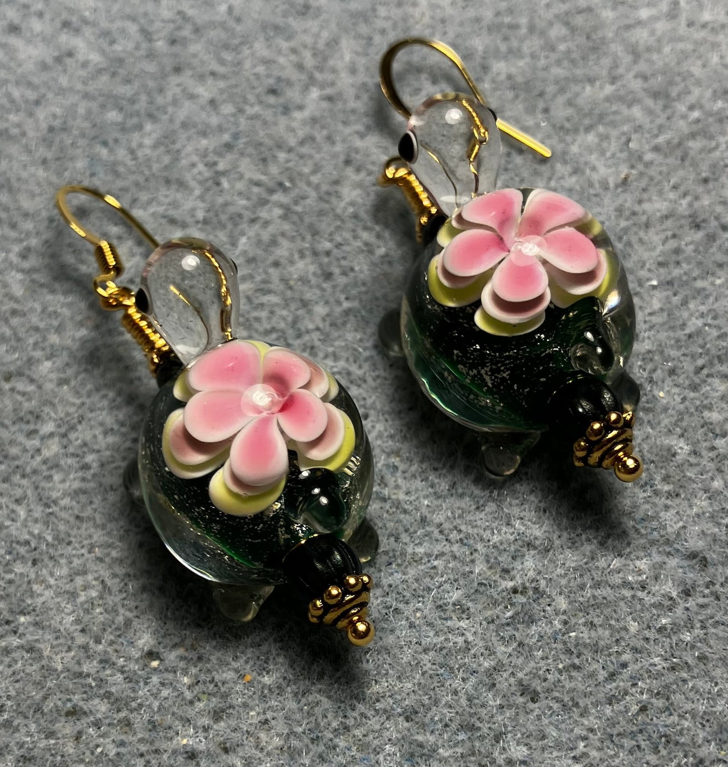 Large dark green and pink lamp work turtle bead earrings adorned with dark green Czech glass beads.