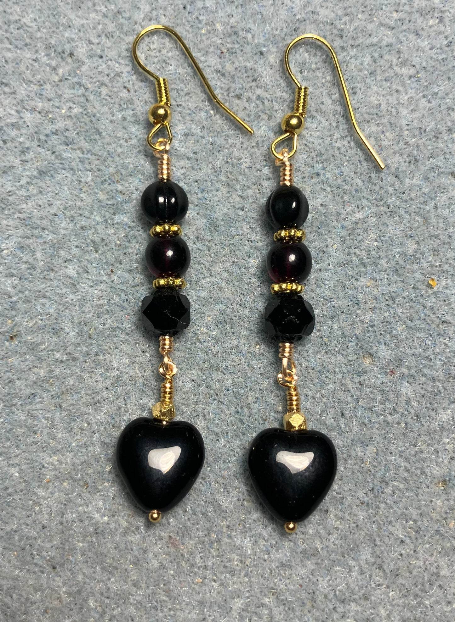 Small black Czech glass heart bead earrings adorned with black Czech glass beads.