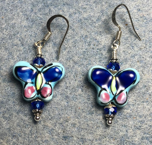 Blue and pink ceramic butterfly bead earrings adorned with dark blue Chinese crystal beads.