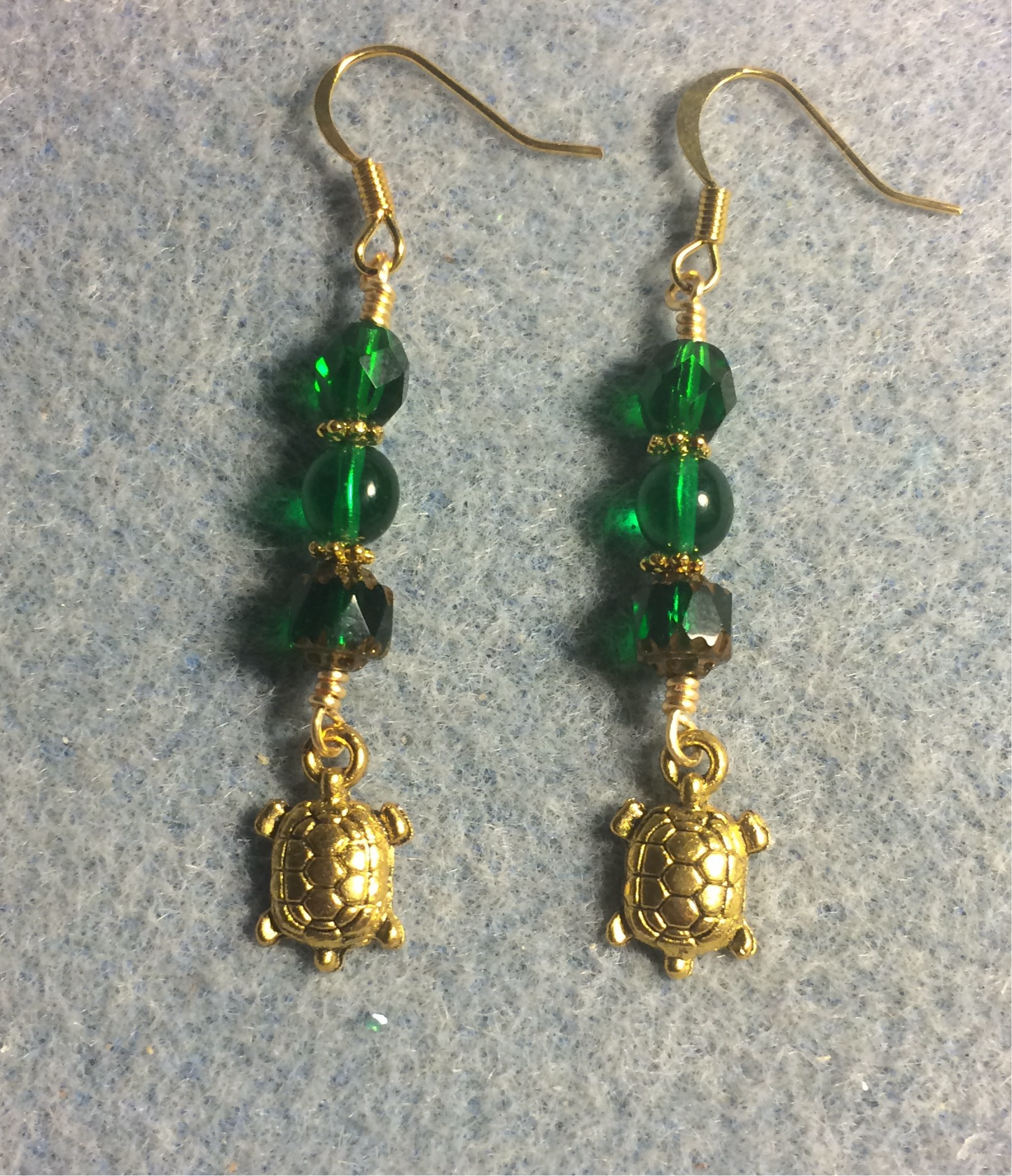 Gold turtle charm earrings adorned with emerald green Czech glass beads